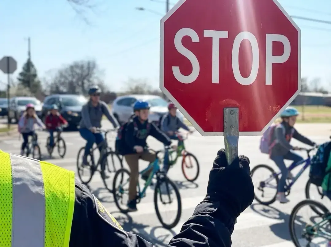 Crossing guard helping children bike safely through an intersection